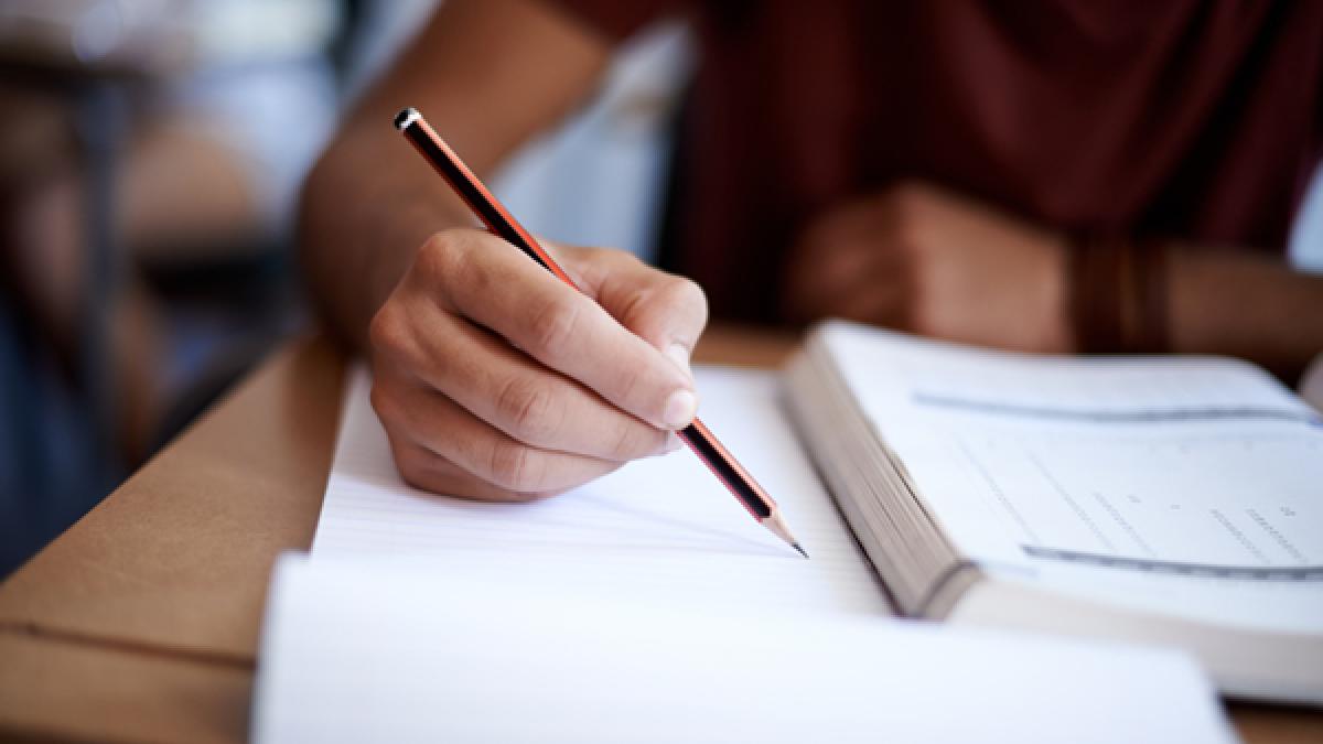 image of student writing on paper